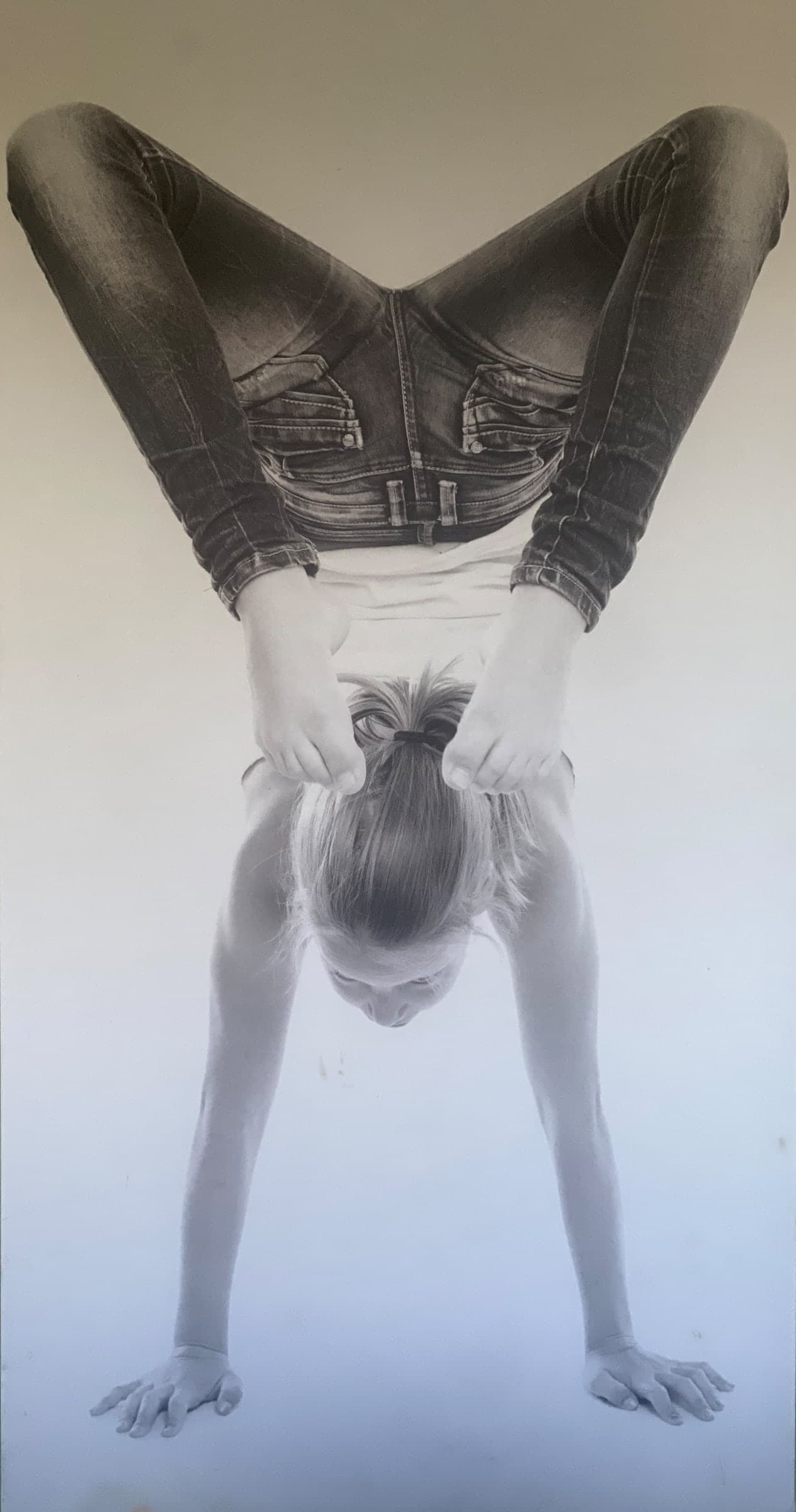 Zwart-witfoto van een handstand met de benen gespreid