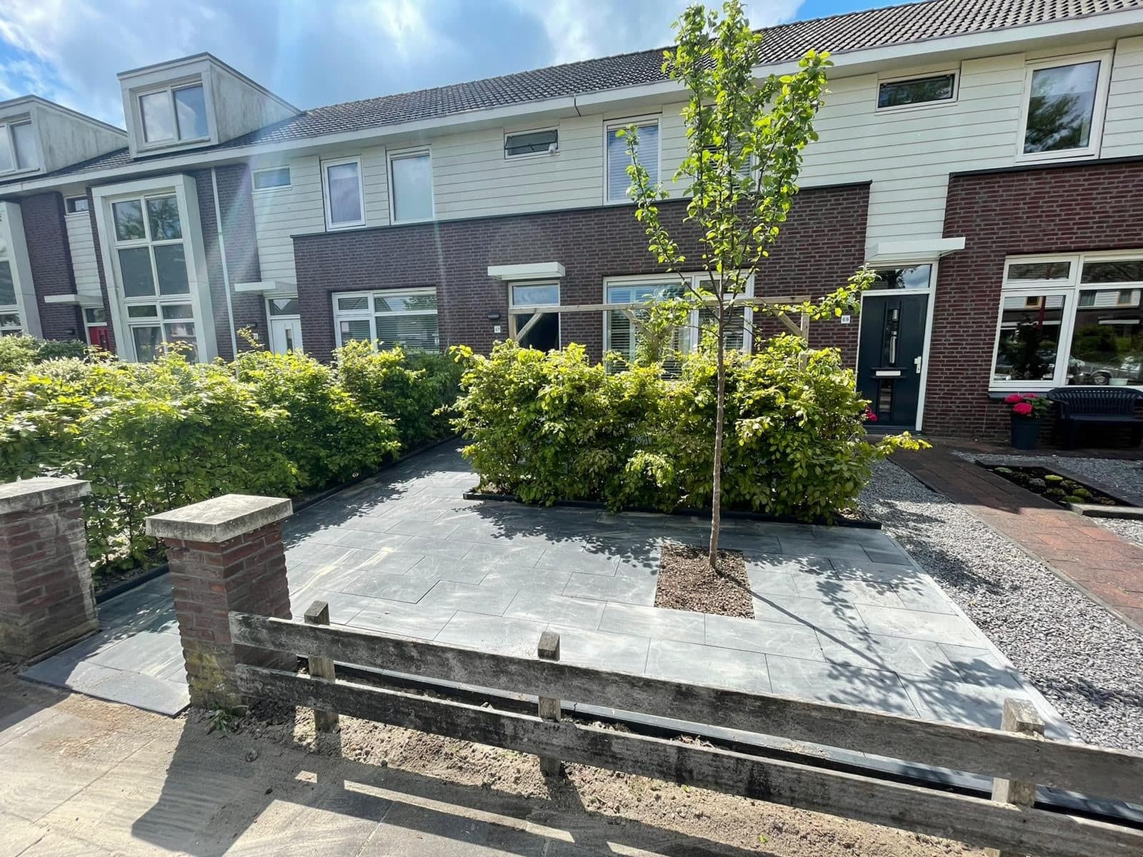 De voorkant van het huis aan het Vliet in Heerenveen, met voortuin en een jonge boom